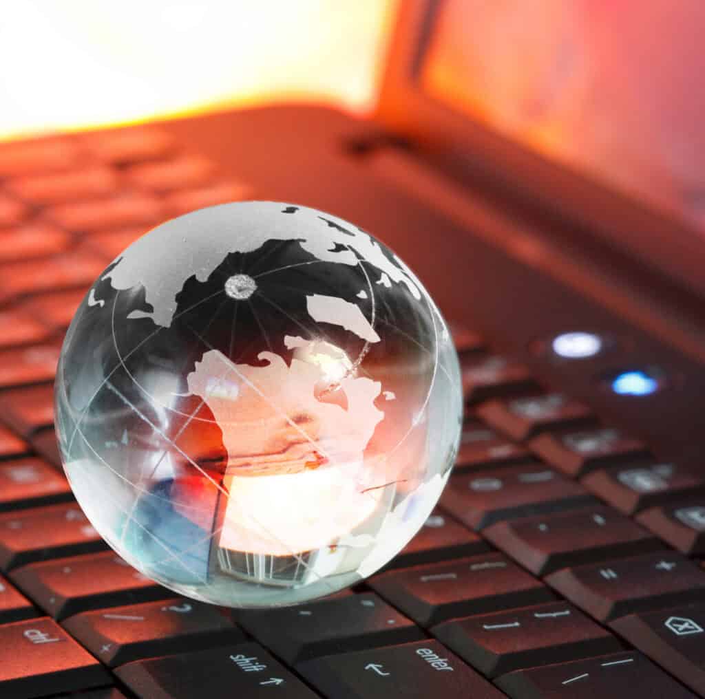 A glass globe engraved with the Seal of Civic Literacy sits on the keyboard of a laptop.