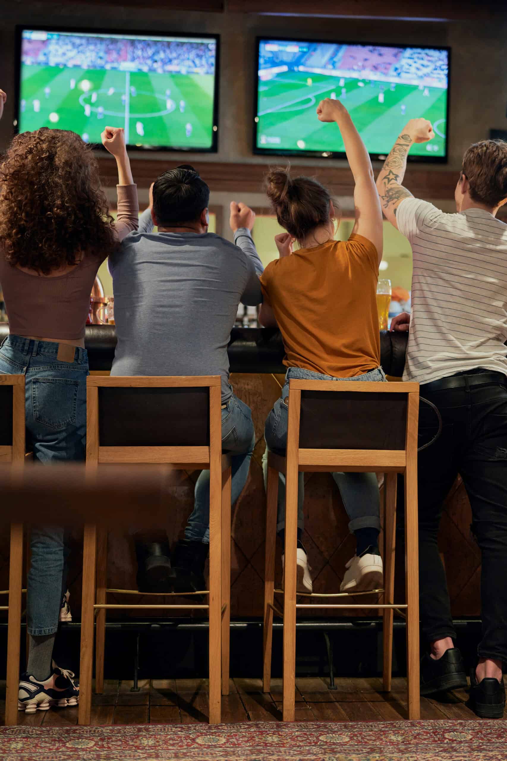 Cheering friends of soccer fans in the pub