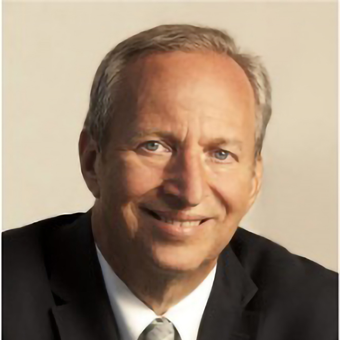Dr. Summers, a middle-aged man with short gray hair, wears a dark suit, white shirt, and light-colored tie, smiling at the camera against a plain light background.