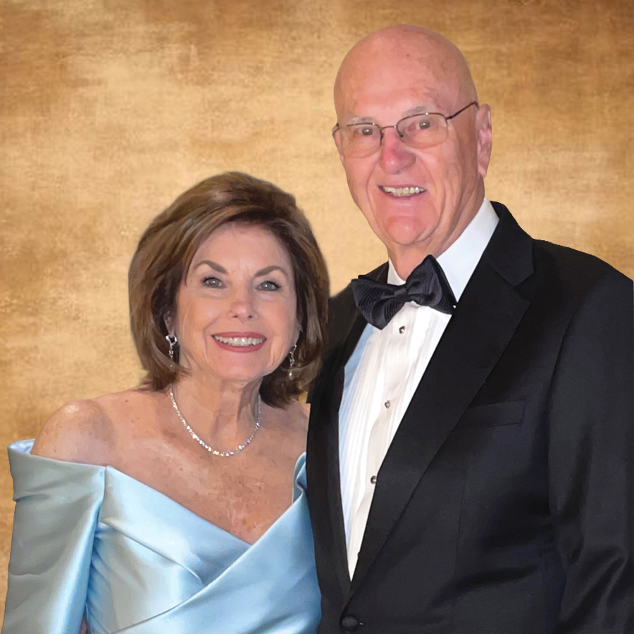 An older woman in a light blue off-the-shoulder gown stands next to an older man in a black tuxedo and bow tie, both smiling as if posing before their history dinner, set against a warm, brown textured background.