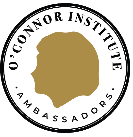 A round logo with a gold silhouette in the center, encircled by the words "O'Connor Institute Ambassadors" and "The Citizen" in black capital letters on a white background.